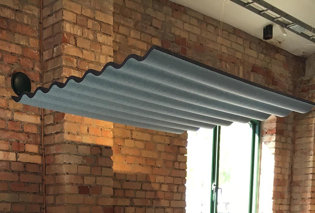 Ceiling mounted acoustic cloud used for noise reduction.