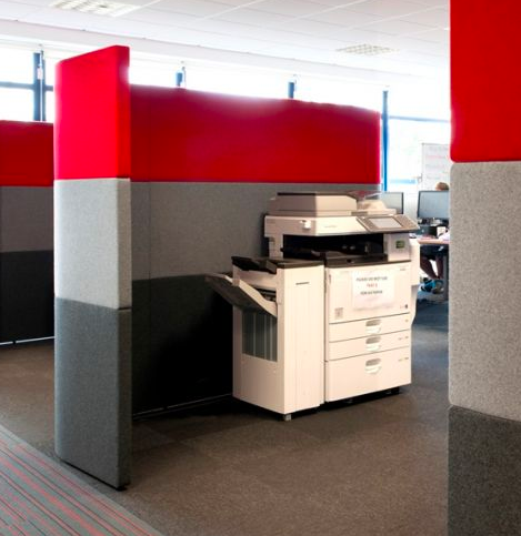 Using an acoustic partition to reduce the noise from a printer in an office.